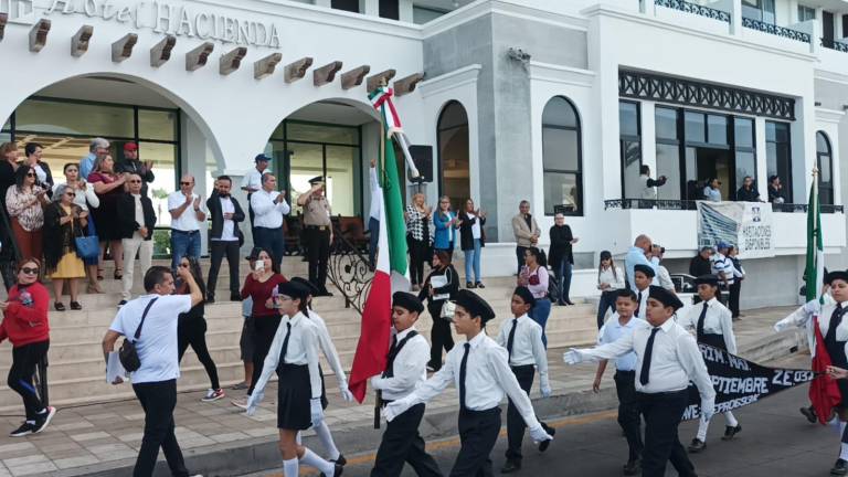 Escoltas de escuelas de Mazatlán desfilan por el paseo costero, la mañana de este jueves.