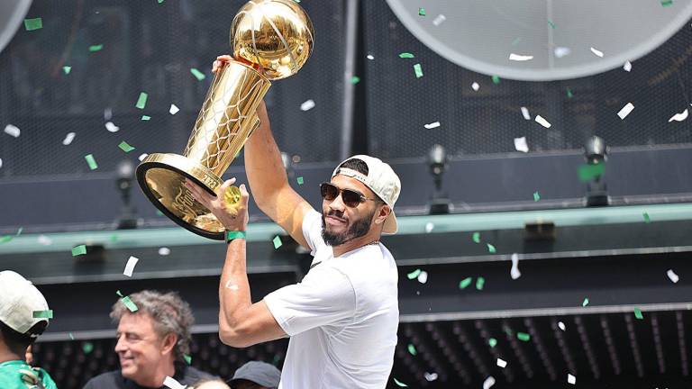 Jayson Tatum muestra el trofeo de campeón de la NBA a los aficionados, que abarrotaron el desfile de los Celtics.