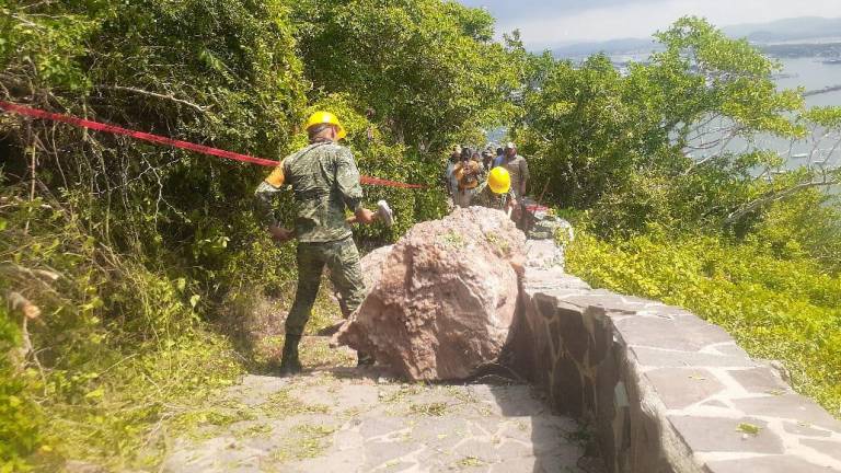 Personal del Ejército Mexicano ayuda a remover las piedras que cayeron en los escalones del acceso al Faro de Mazatlán.