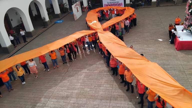 Lazo naranja formado por personal del Ayuntamiento de Culiacán en la explanada del Palacio Municipal.