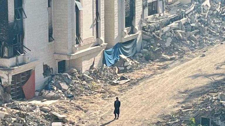 Una persona camina entre las ruinas de un barrio de Gaza.