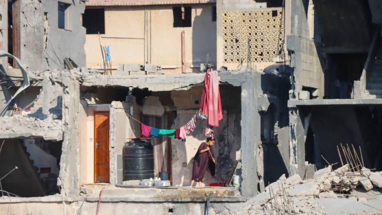 Una mujer limpia el suelo de un edificio destruido en Gaza.