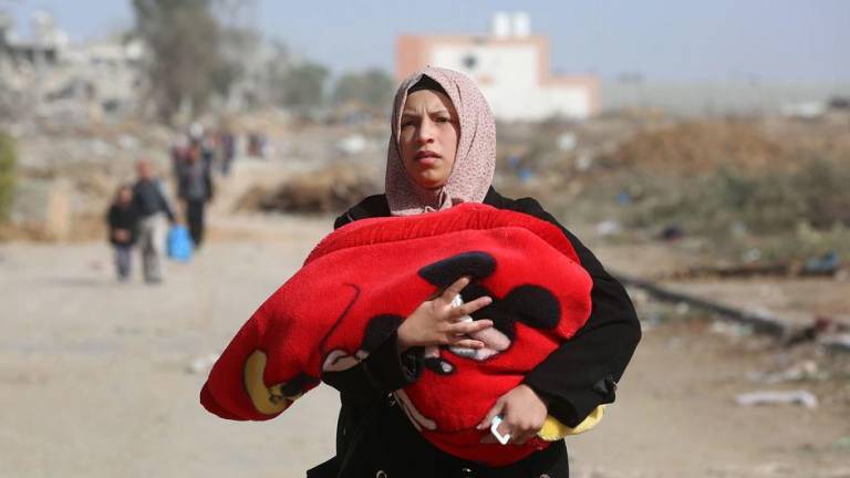 Una mujer huye del barrio de Al Zeitoun en la ciudad de Gaza, al sur de la Franja de Gaza.