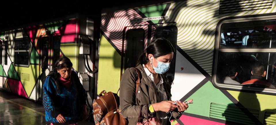 $!Dos mujeres en el tren de la Ciudad de México se protegen del coronavirus con mascarillas.