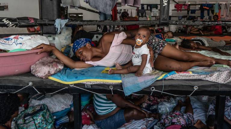 Hombres, mujeres y niños desplazados se refugian en un estadio de boxeo en el centro de Puerto Príncipe tras huir de sus hogares durante los ataques de bandas en agosto de 2023.