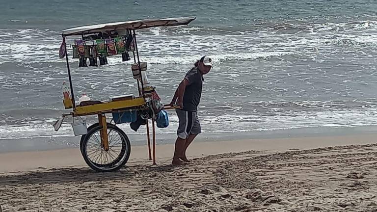 Ulises Gustavo camina más de 2 kilómetros de playa diariamente ofreciendo sus productos.