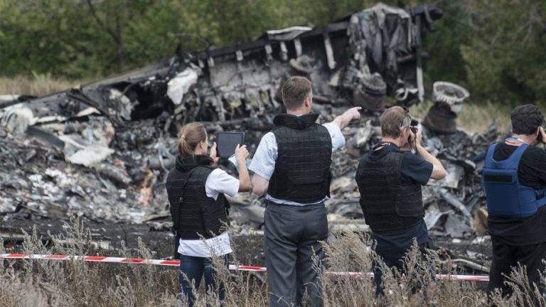 Miembros de la Misión Especial de Observación en Ucrania de la Organización para la Seguridad y la Cooperación en Europa examinan el lugar del accidente en julio de 2014.